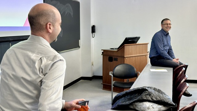 The professor listening to the guest speaker