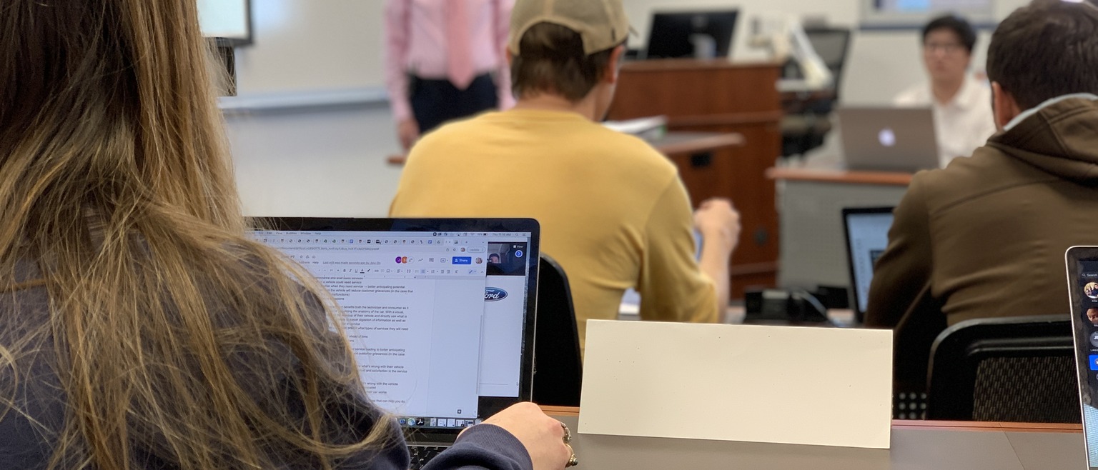 Students with laptops facing professor